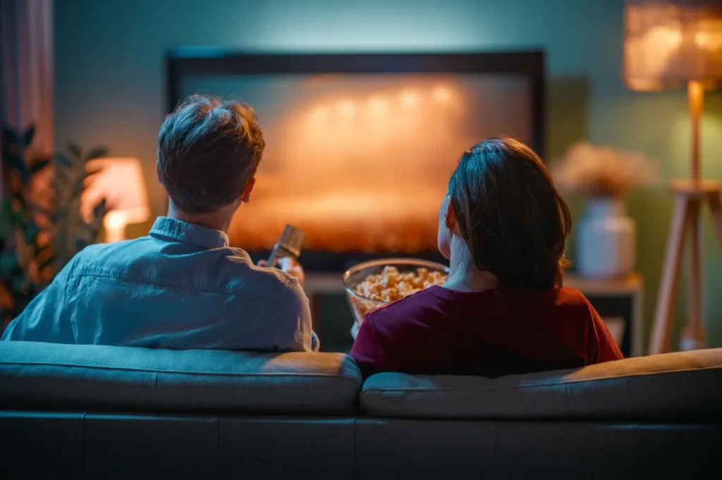 Pareja sentada viendo películas tristes en Netflix.