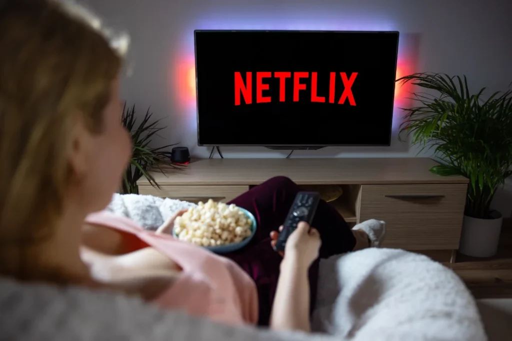Mujer viendo película triste en Netflix con palomitas.