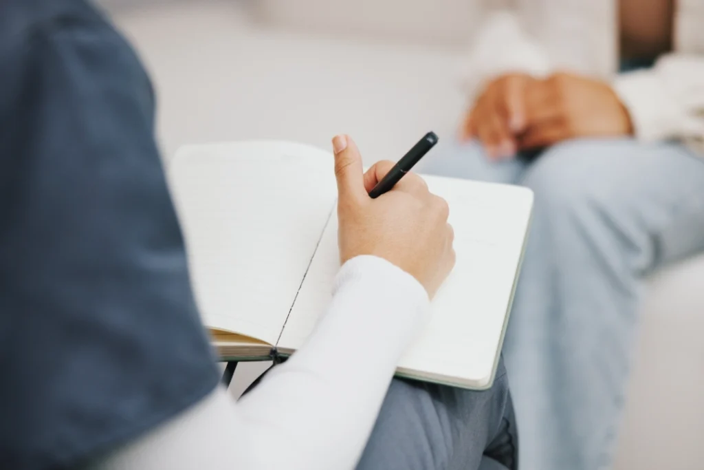 Mujer analizando a un paciente en consulta psicológica.