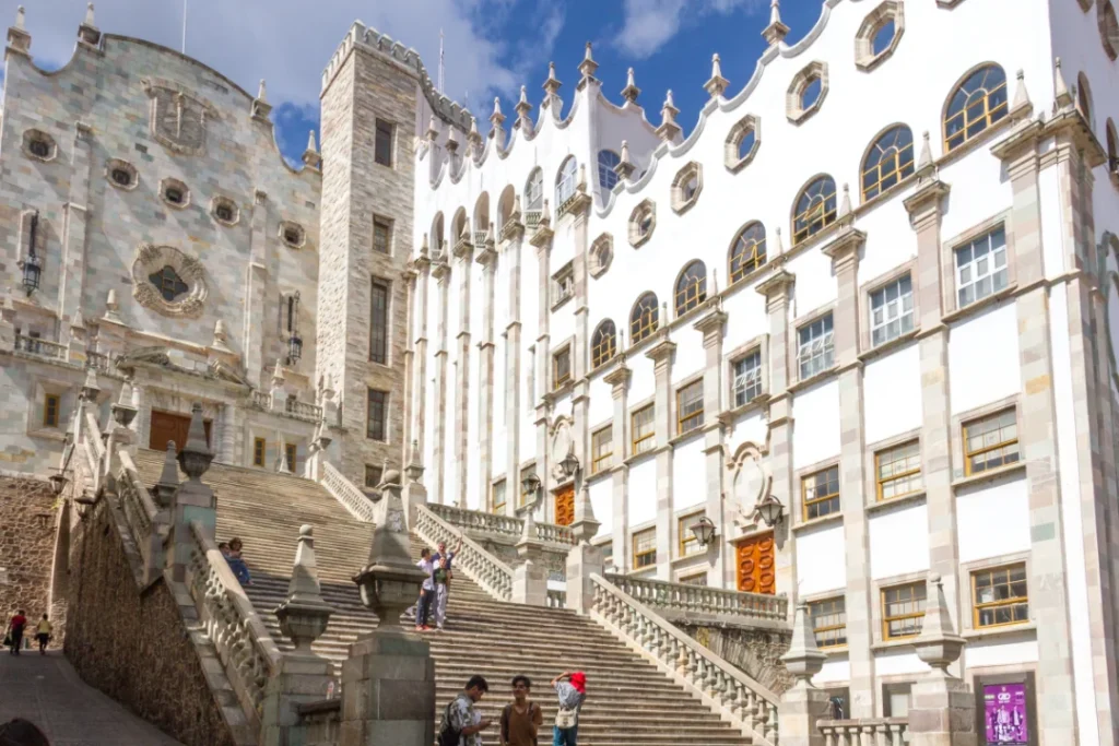 Entorno universitario con estudiantes y edificios de la Universidad de Guanajuato.