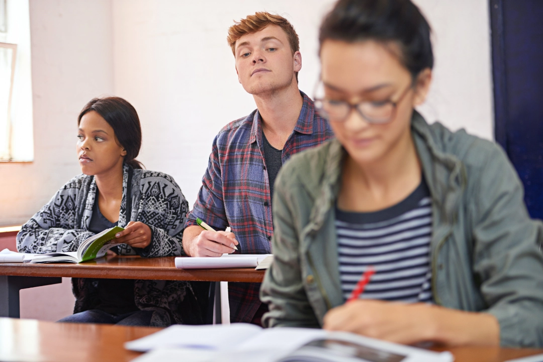 Alumno poniendo a prueba su ética universitaria copiando en un examen.